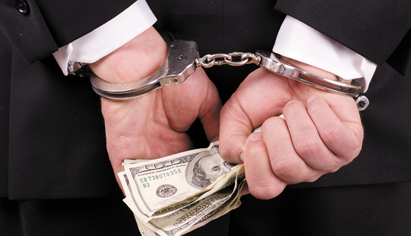 arrested businessman holding hundred dollar bills isolated on a white background